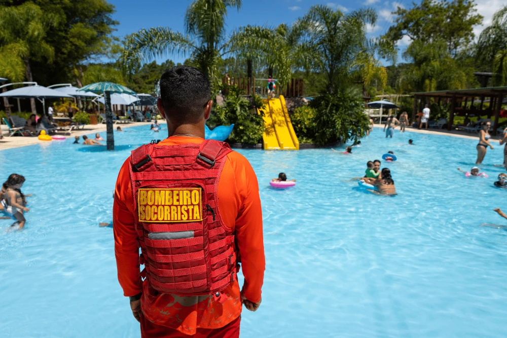 bombeiro socorrista olhando para piscina com crianças